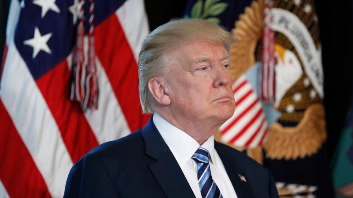 President Donald Trump listens last month as Treasury Secretary Steve Mnuchin speaks at the Treasury Department in Washington.