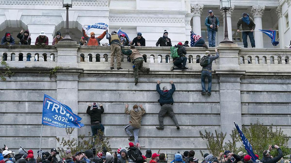 FILE - In this Jan. 6, 2021 file photo rioting supporters of President Donald Trump climb the west wall of the the U.S. Capitol in Washington. Historians say Trump’s legacy and his electoral undoing will be largely shaped by rhetoric aimed at stirring his largely white base that tugged at the long-frayed strands of race relations in America. (AP Photo/Jose Luis Magana, File)
