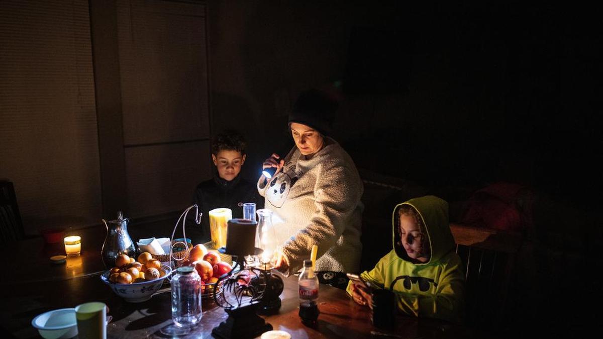 Manessa Grady adjusts an oil lamp while spending time with her sons Zechariah, 8, and Noah, 9, right at their home in Austin, Texas, on Tuesday evening, Feb. 16, 2021. Winter storms plunged large parts of the central and southern United States into an energy crisis as frigid blasts of Arctic weather crippled electric grids and left millions of Americans without power amid dangerously cold temperatures. (Tamir Kalifa/The New York Times)