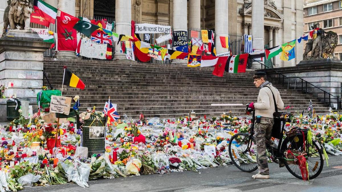 A man looks at a memorial site for the victims of the Brussels attacks at the Place de la Bourse in Brussels, Belgium, Friday, April 1, 2016. The Brussels city archive today started collecting messages and drawings to protect and preserve them.