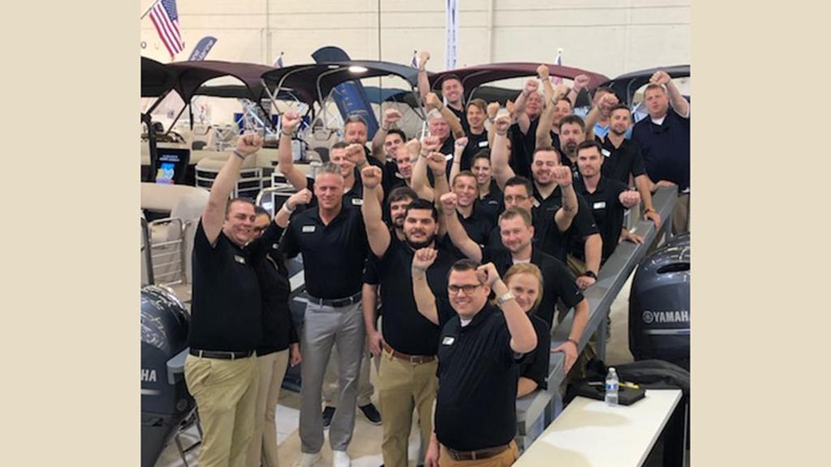 Employees of Phil Dill Boats of Lewisville show off their “Shari Strong” bracelets at the Fort Worth Boat Expo.