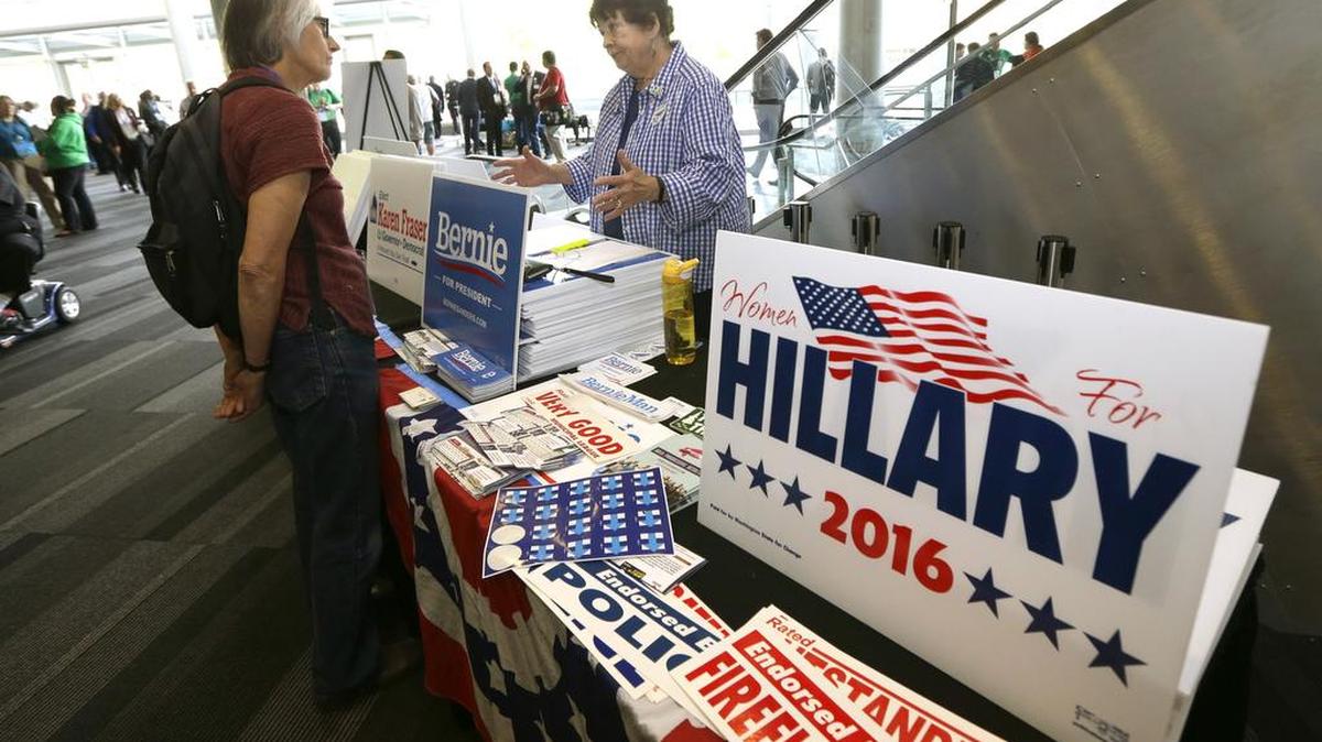 Sen. Maralyn Chase, D-Edmonds, right, talks with Diane Jones, left, at a table displaying signs in support of Democratic Presidential candidates Hillary Clinton and Sen. Bernie Sanders, I-Vt., Friday, June 17, 2016, at the Washington state Democratic Convention in Tacoma, Wash. State Democrats are scheduled to meet through Sunday to pass a party platform and finish electing delegates to the national convention this summer.