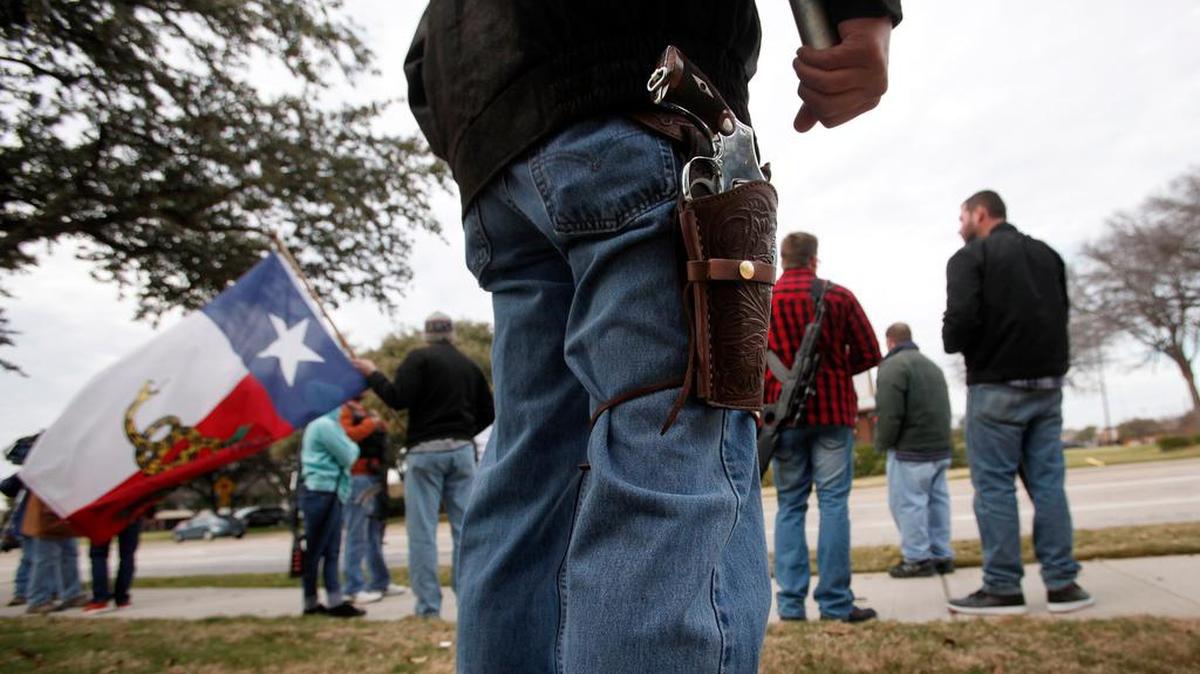 Rob Paige with a model 1917 Army revolver joins about two-dozen activist Jan. 1 during an Open Carry Walk in front of the Cane’s restaurant on North Collins Street in Arlington.