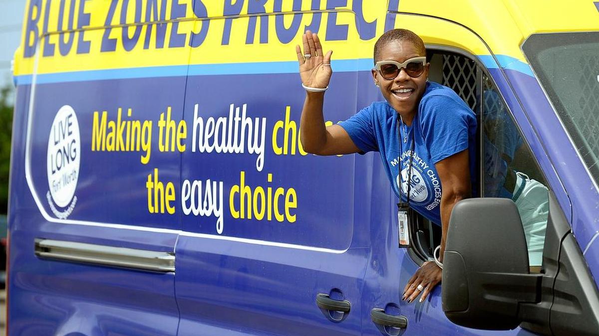 Healthways consultant Peacock Taylor waves from the Blue Zone Project float in the Juneteenth parade in Forest Hill..