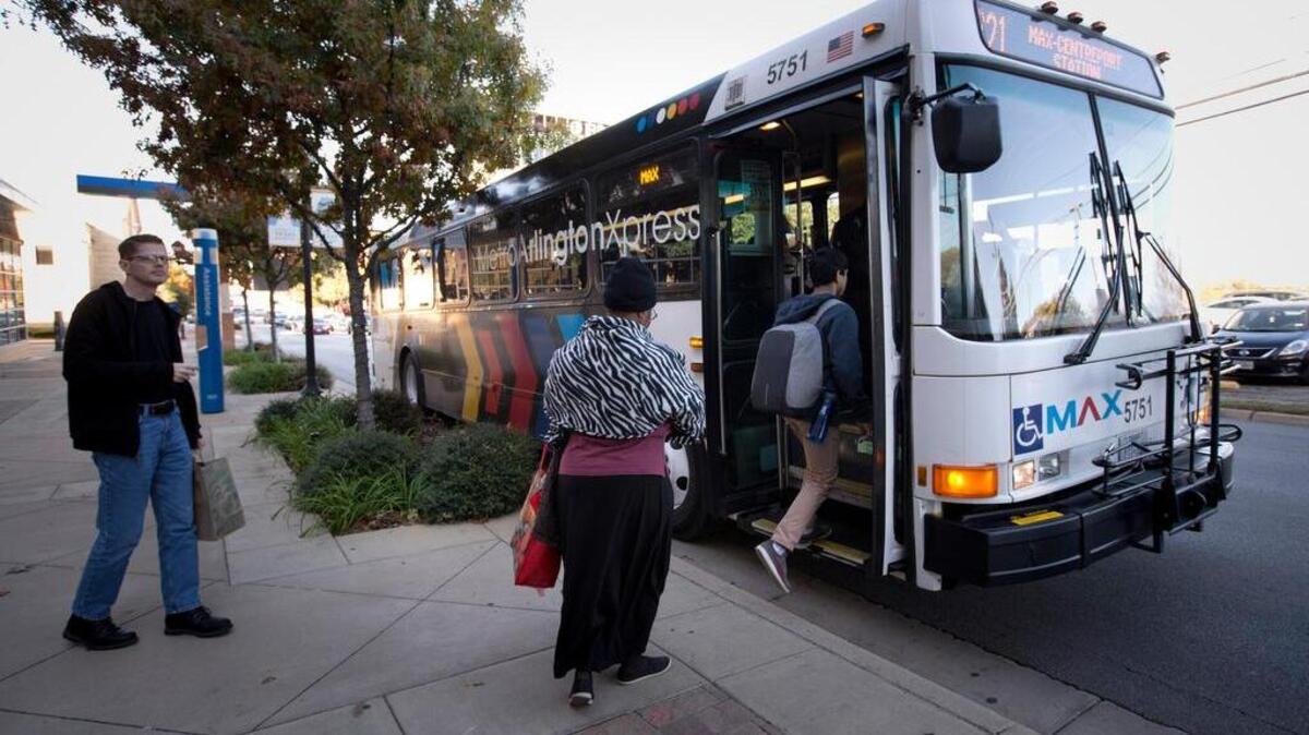 Riders, at the bus stop near the UTA campus to Centerport, take the MAX bus service in Arlington in 2016.