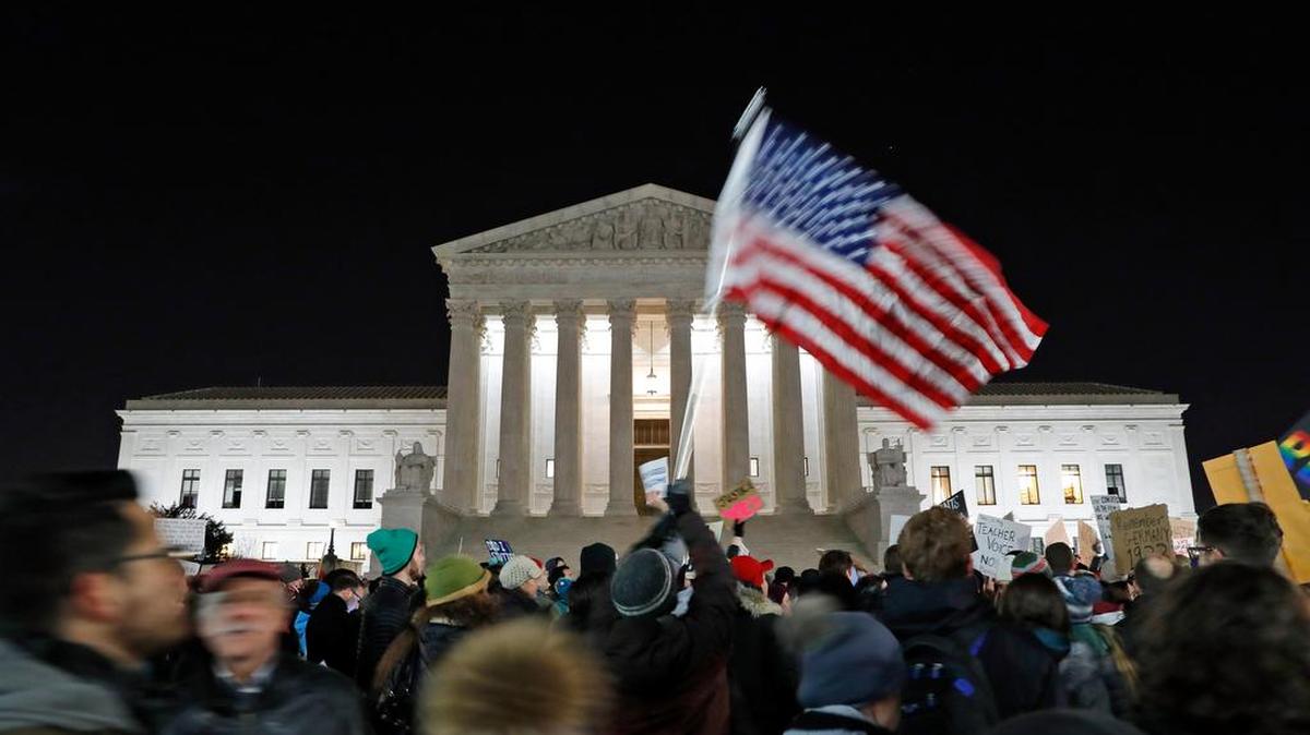 A protester waves an American flag in front of the Supreme Court during an immigration demonstration last month.
