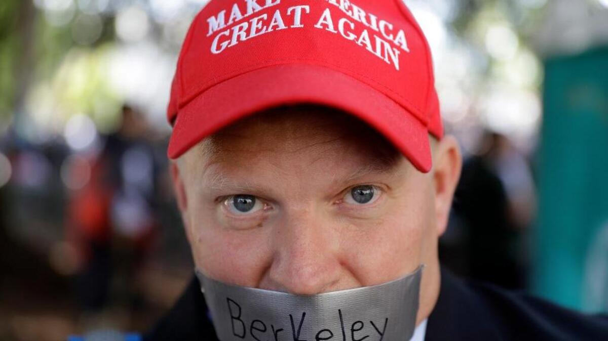 Daryl Tempesta tapes a sign over his mouth in protest during a demonstration Thursday, April 27, 2017, in Berkeley, Calif. Demonstrators gathered near the University of California, Berkeley campus amid a strong police presence and rallied to show support for free speech and condemn the views of Ann Coulter and her supporters.