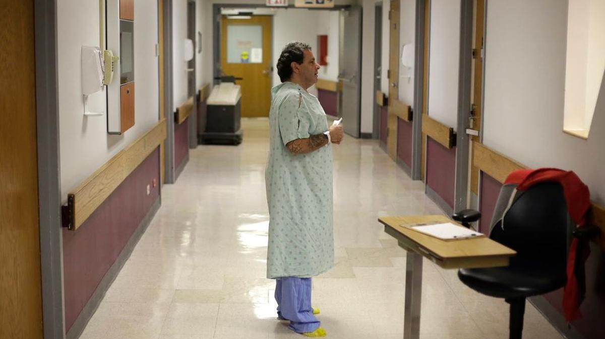 A patient pleads with a medical detox team member to get him into a sober-living facility near his family in Oct.