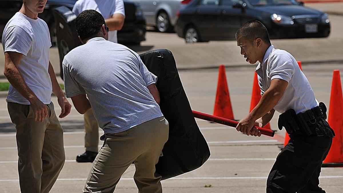 Peter Wang with the Richardson Police department works through the baton strike drill while under the influence of a pepper spray agent. The North Central Texas Council of Governments' Regional Police Academy held a Oleoresin Capsicum or commonly known as Pepper Spray, training Wednesday, August 13, 2008 in Arlington. The training, part of the Basic Course in Applied Police Science in the 14th week of a 21 week class, teaches officers how to still work in the field in case of exposure. Officers are sprayed in the face in forehead area with same spray used by their various departments. About 16 county area law enforcement agencies send hired officers to the basic Academy for their State Peace Officers license. During the training, officers go through a 5 station course which included victim spray, knee strike, elbow strike, batton strike and threat assessment. A washing station to wash spray from their eyes concluded the exercise.