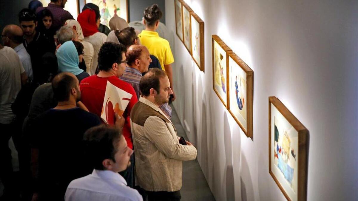 Iranians look at paintings of Narges Mousavi in "House of Free Designers" art gallery in Tehran, Iran, Friday, Aug. 11, 2017. The daughter of Iran's opposition leader Mir Hossein Mousavi, who has been under house arrest since early 2011, is holding a painting exhibition in Tehran.
