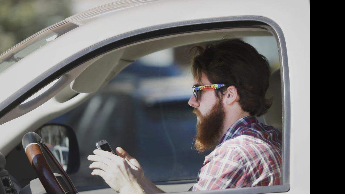 
 A man uses his cellphone as he drives through traffic in Dallas. 
