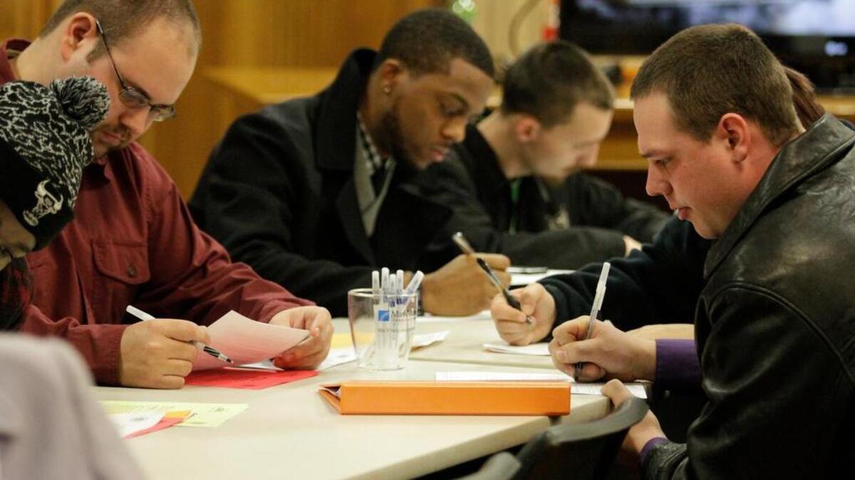 People fill out application forms at a job fair in Michigan. The national unemployment rate is 5 percent.