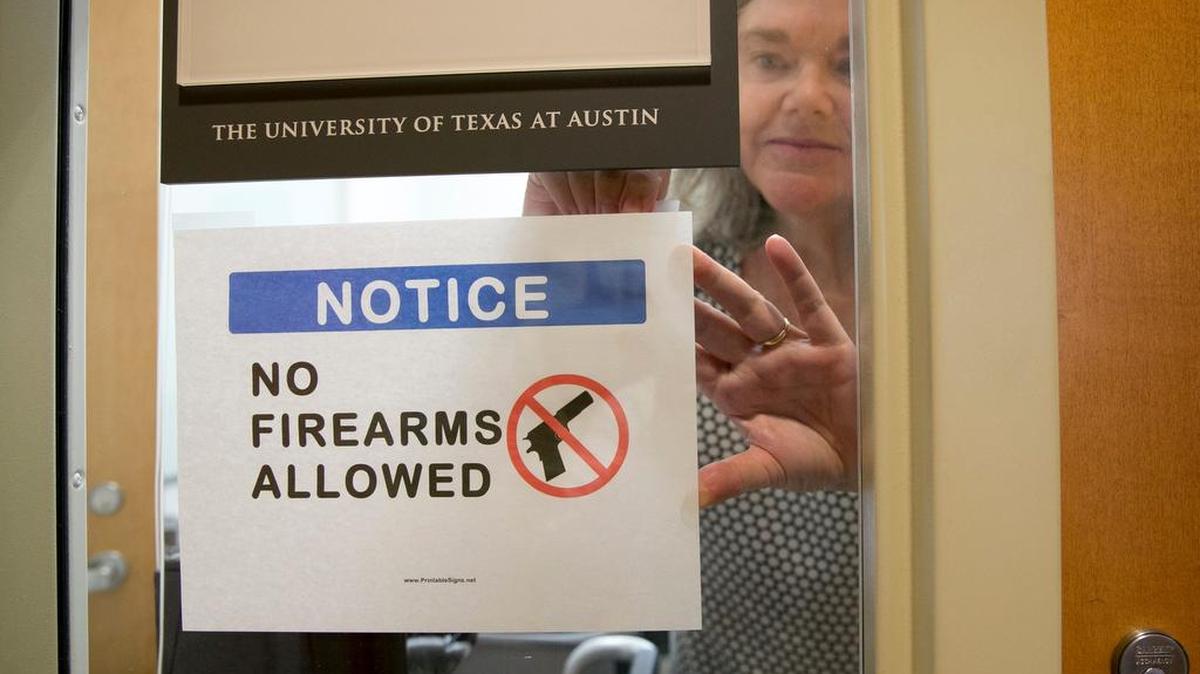 University of Texas at Austin Anthropology professor Pauline Strong posts a sign prohibiting guns at her office on Aug. 1, the first day of the new campus-carry law.