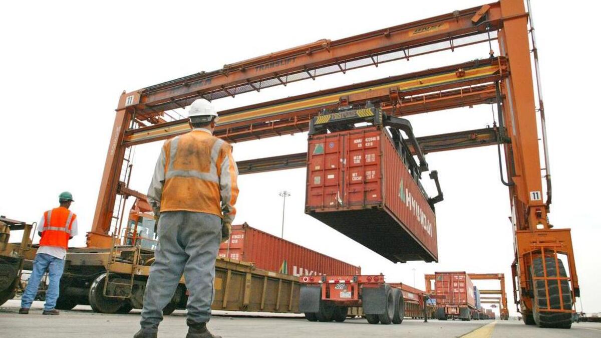 Containers are lifted from trailers onto rail flatcars by a huge gantry that straddles both the trailers and the train.