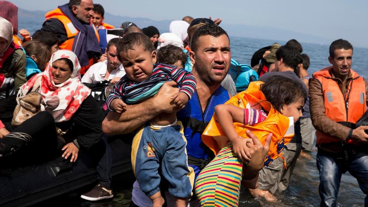 Syrian refugees arrive aboard a dinghy on Sept. 10 after crossing from Turkey to the Greek island of Lesbos.