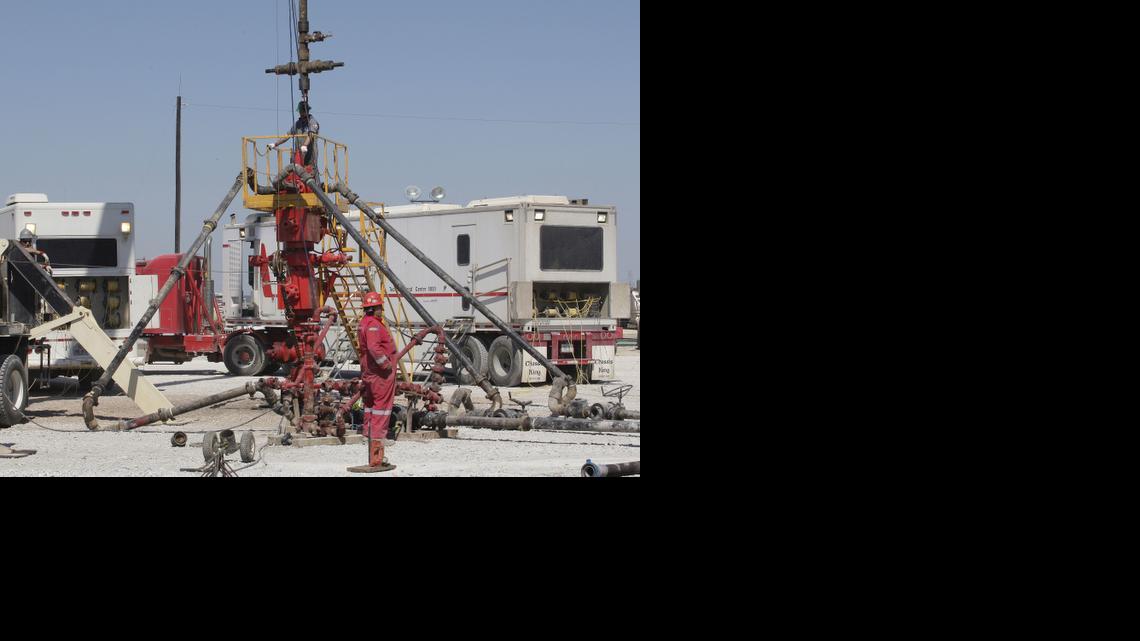 
Workers prepare to pump millions of gallons of fracking fluids down a well.
