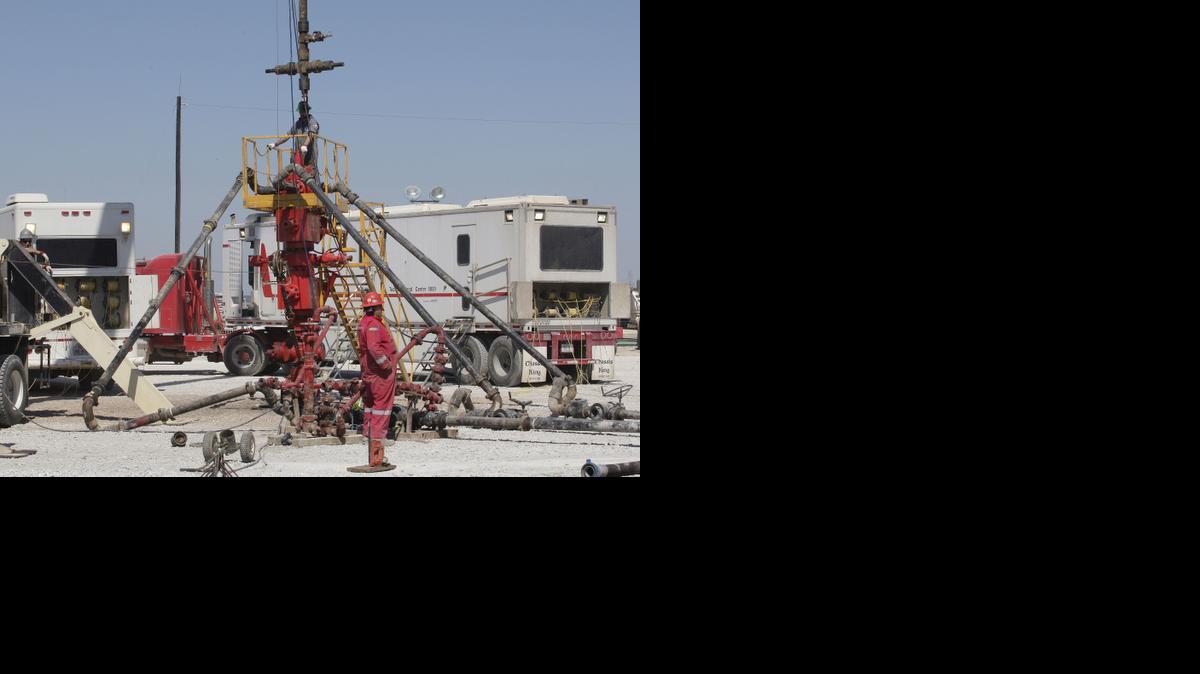 
Workers prepare to pump millions of gallons of fracking fluids down a well.
