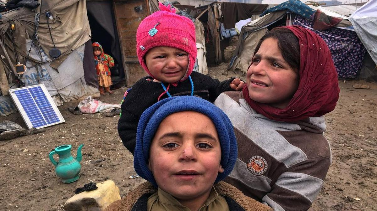 Three children from a family of former war refugees stand near the tents they now live in on Jan. 25 in Kabul, Afghanistan.