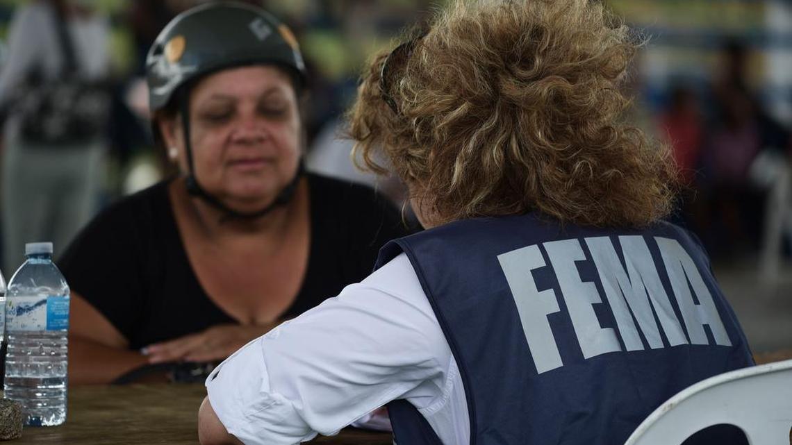 A resident meets with a FEMA representative after Hurricane Maria in Las Piedras, Puerto Rico, Monday