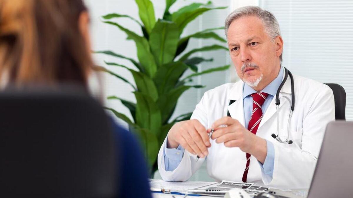 Doctor talking to his patient in his office.