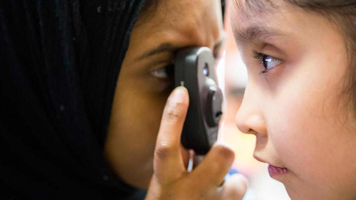 Salwa Azeez, left, uses a retinoscope to examine Smeily Perez's eyes during the 4th Annual Kids Vision Fest on Feb. 5, 2016, at the TCC Trinity River Campus in Fort Worth. About 1,000 students from Fort Worth ISD received eye exams and new glasses at no cost provided by the Essilor Vision Foundation.