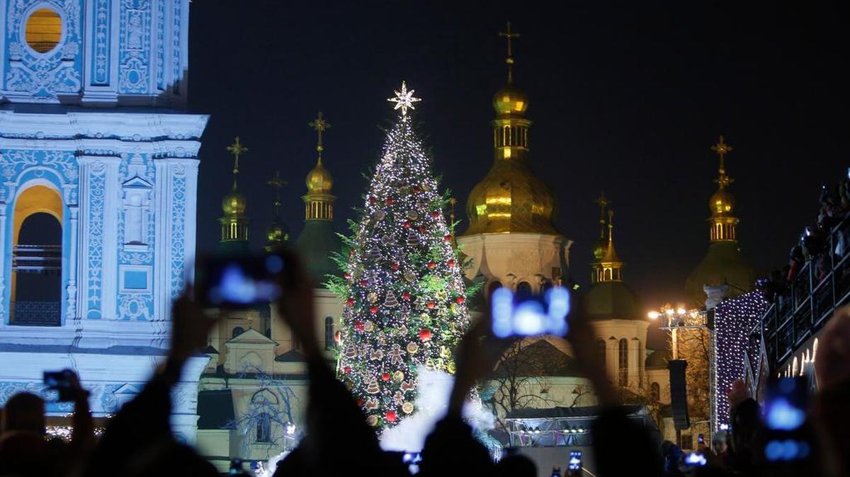 Ukrainians take pictures of the Christmas tree near St. Sophia’s Cathedral in downtown Kiev, Ukraine