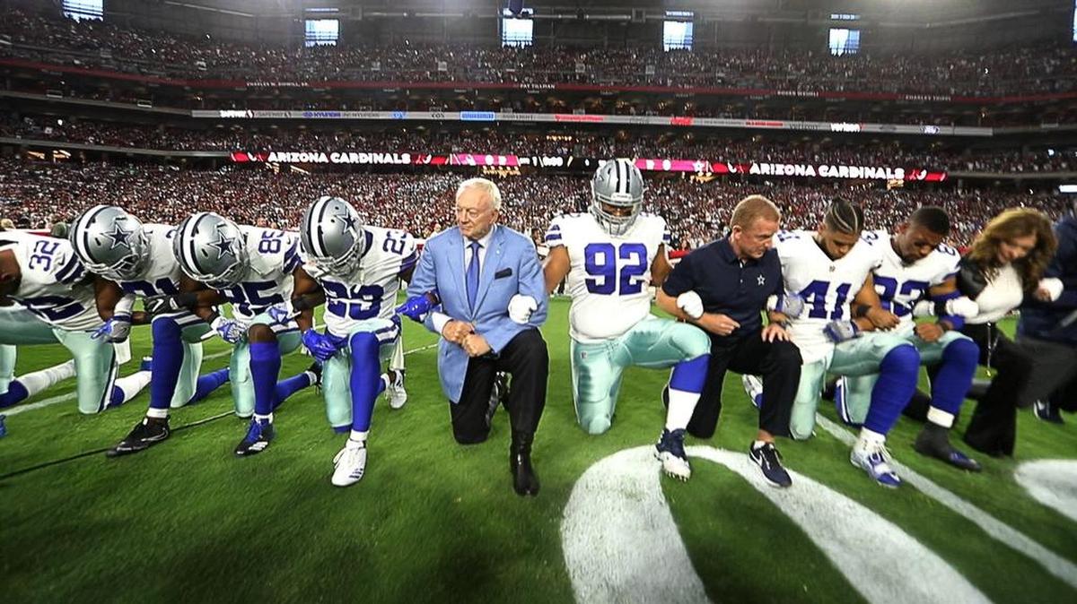 Jerry Jones and the Cowboys take a knee before their game against the Arizona Cardinals on Monday.