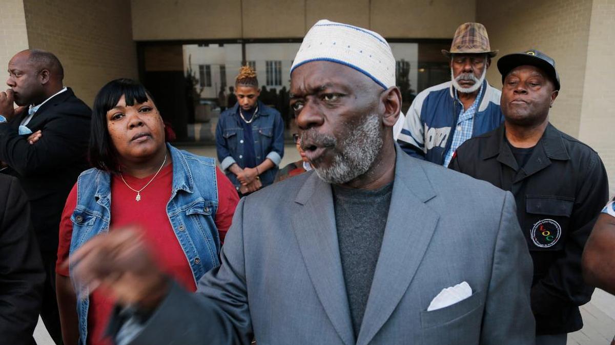 Pastor Michael Bell speaks Jan. 31 outside City Hall on the arrests of Jacqueline Craig (left) and her daughters.