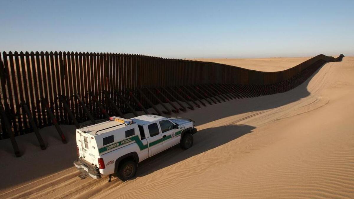 A border patrol vehicle patrols along a section of the controversial US-Mexico border fence expansion on previously pristine desert sands between Yuma, Ariz., and Calexico, Calif.