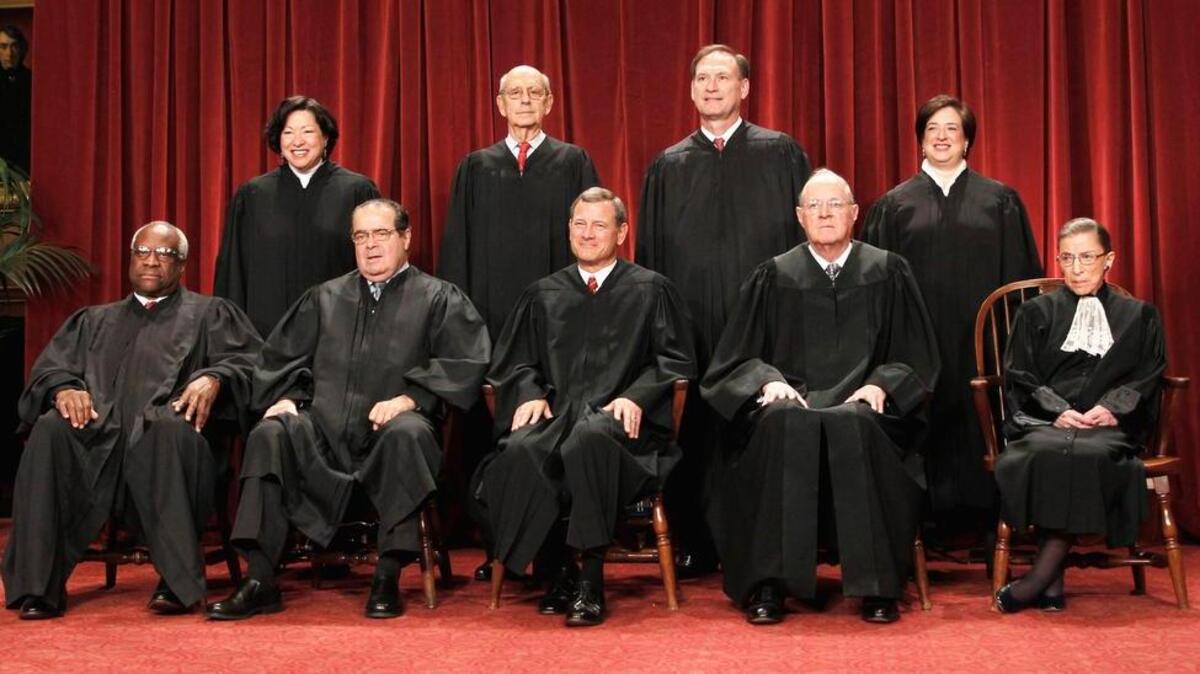 Justices of the U.S. Supreme Court gather for a group portrait at the Supreme Court in Washington. Seated from left are Associate Justices Clarence Thomas, and Antonin Scalia, Chief Justice John Roberts, Associate Justices Anthony M. Kennedy, and Ruth Bader Ginsburg. Standing, from left are Associate Justices Sonia Sotomayor, Stephen Breyer, Samuel Alito Jr., and Elena Kagan.