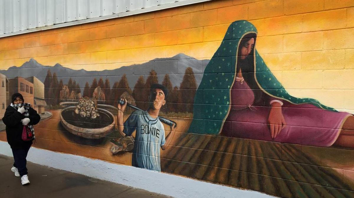A resident walks past a mural in the Segundo Barrio of El Paso. Pope Francis visits neighboring Juárez Wednesday.