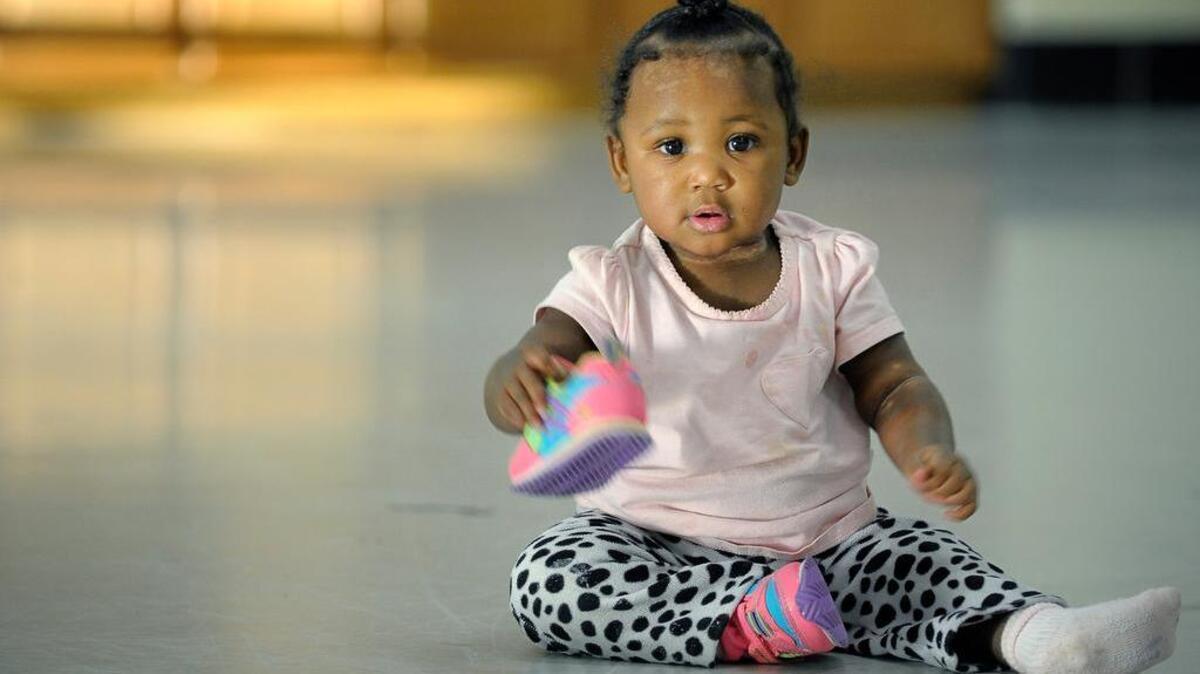 Tanisha Ealem, 10 months, plays with her shoe in 2014 at Union Gospel Mission in Fort Worth. The Ealem family was living at Union Gospel Mission, having been homeless for two years.