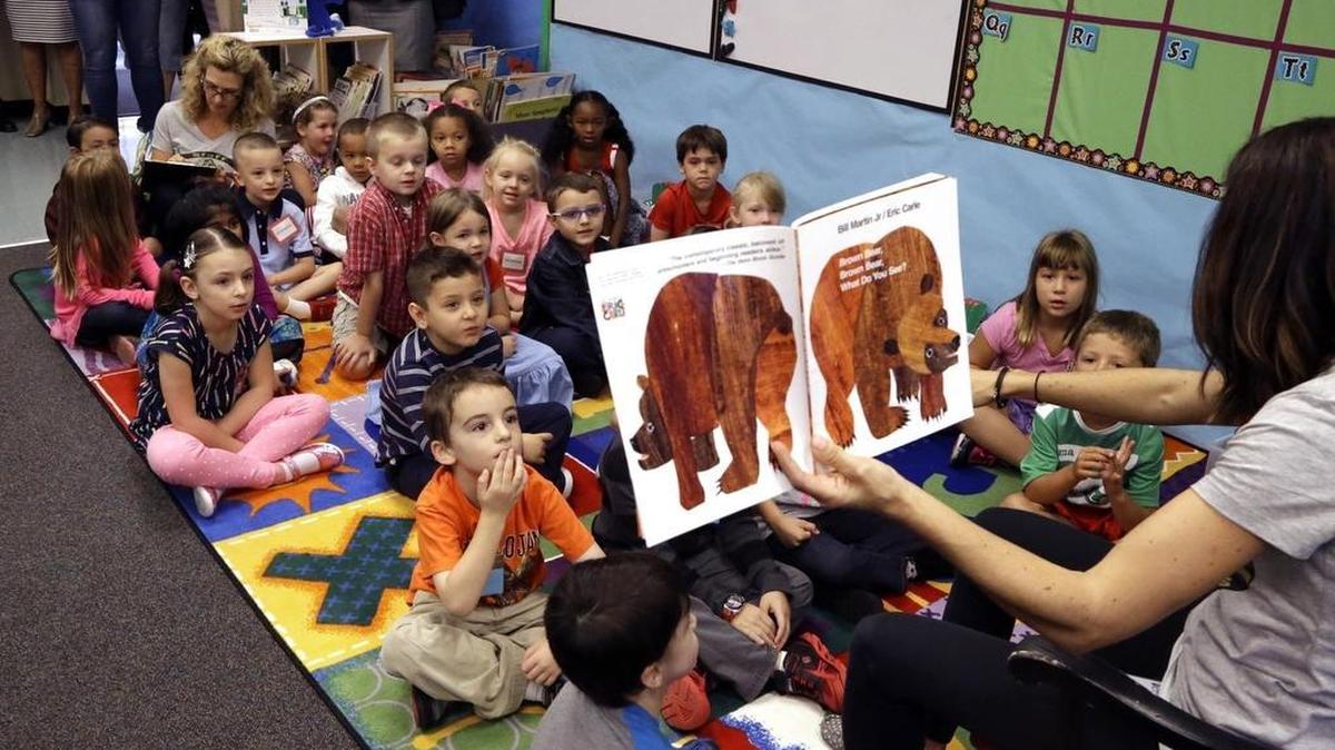 Kindergarten students listen as teacher Amy Holland reads on the first day of school at Nancy Ryles Elementary School in Beaverton, Ore. in 2015.