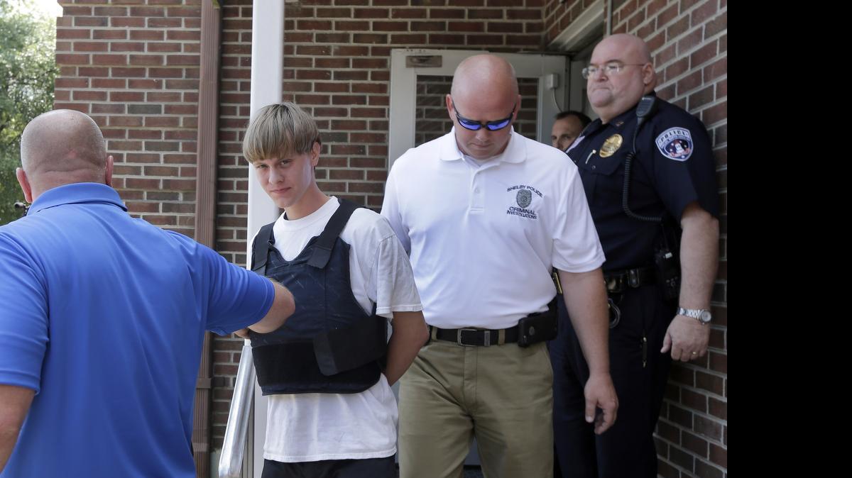 
Charleston, S.C., suspect Dylann Storm Roof, left, is escorted by officers.
