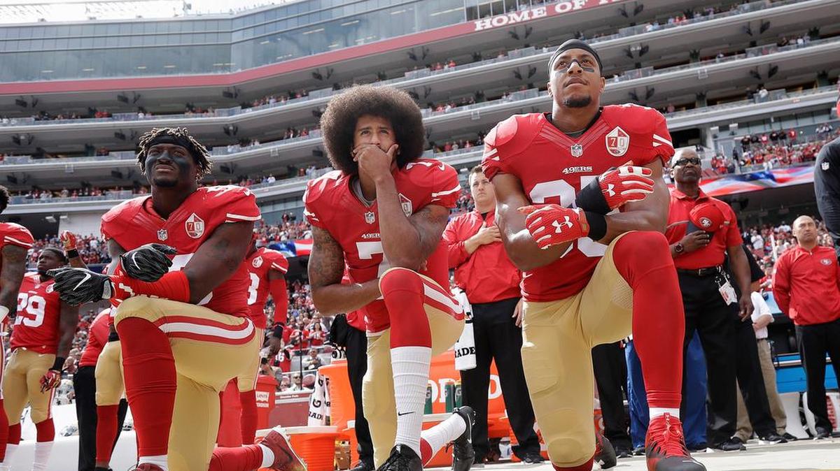 Eli Harold, Colin Kaepernick, center, and Eric Reid kneel during the national anthem before an NFL football game against the Dallas Cowboys in Santa Clara, Calif. in 2016.