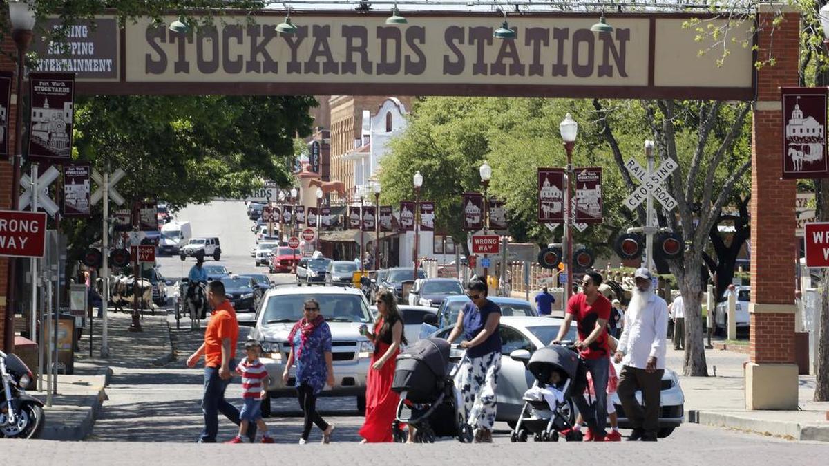 Visitors cross East Exchange Avenue in the Fort Worth Stockyards. The City Council has approved the smaller of two historic district plans for the area.