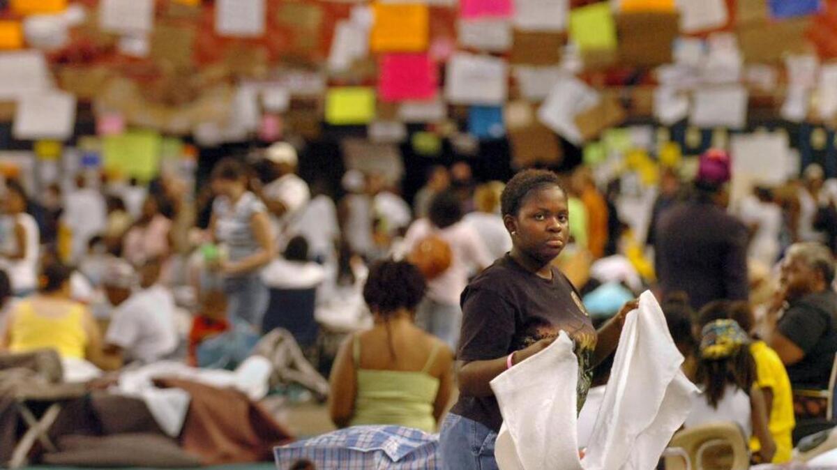 
Hurricane Katrina evacuees crowd the floor of the the Astrodome in Houston on Sept. 7, 2005. Missing person posters hang in the background. 
