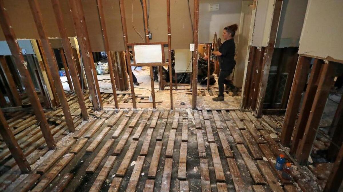 Volunteer Jenny Killingsworth helps remove flooring from a home destroyed by floodwaters in the aftermath of Hurricane Harvey Monday, Sept. 4, 2017, in Houston.