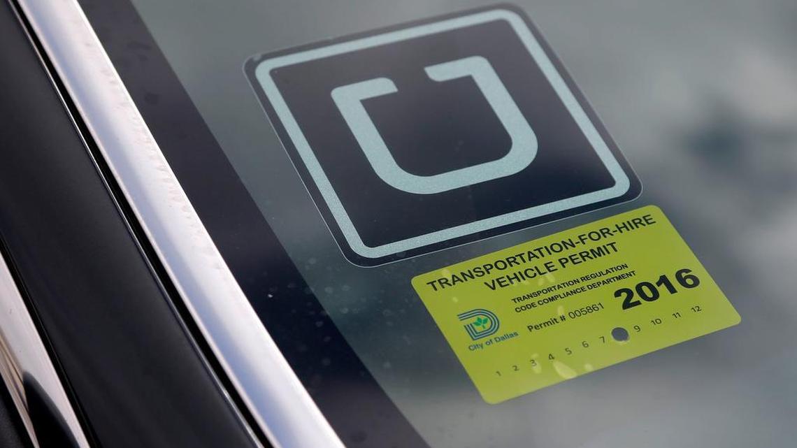 An Uber driver displays the Uber decal and the Dallas transportation for hire vehicle permit on his windshield at DFW International Airport.