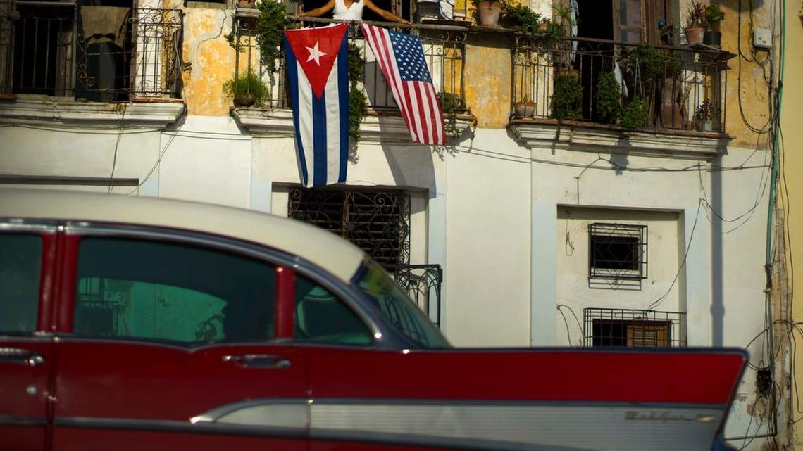 Javier Yanez looks out from his balcony in Old Havana, where he displays U.S. and Cuban flags.