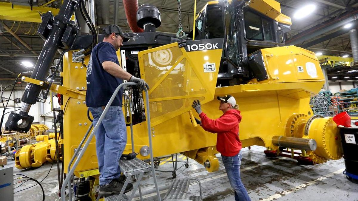 Workers attach a panel to a John Deere 1050K Crawler Dozer at John Deere Dubuque Works in Dubuque, Iowa.