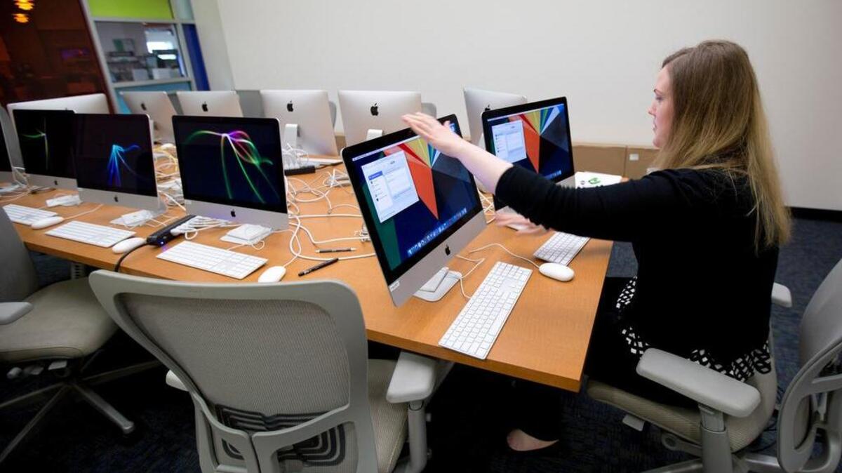 Caroline Tait, the adult information supervisor at the Bedford library, configures computers for public use on August 6, 2015.
