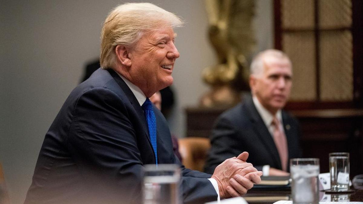 President Donald Trump, accompanied by Sen. Thom Tillis, R-N.C., right, smiles during a meeting with Republican Senators on immigration in the Roosevelt Room at the White House, Thursday, Jan. 4, 2018, in Washington.