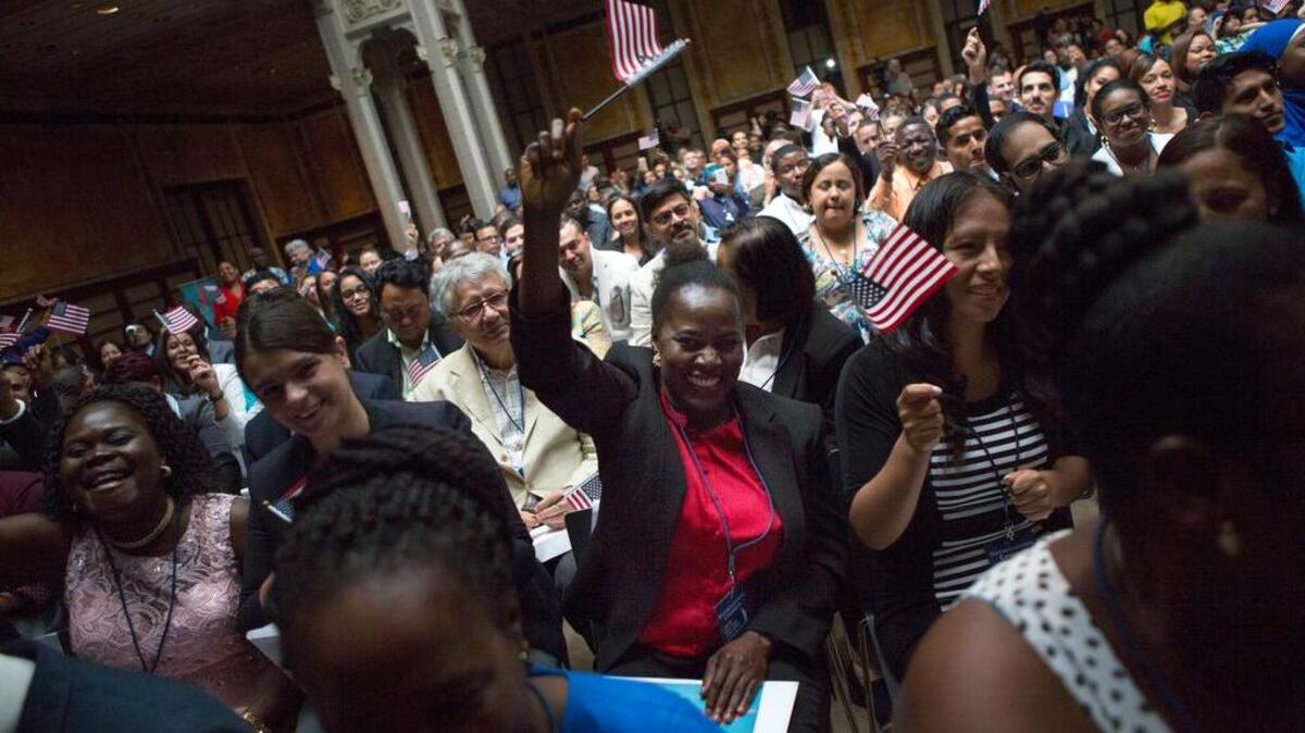Verta Anyaakuu, center, of the Congo, cheers and shouts, "I'm a proud American," causing the crowd to cheer at the closing of a naturalization ceremony on Friday, June 30, 2017, at the New York Public Library in New York. Over 190 immigrants from 59 countries became American citizens at the fourth annual Independence Day naturalization ceremony hosted by the library.