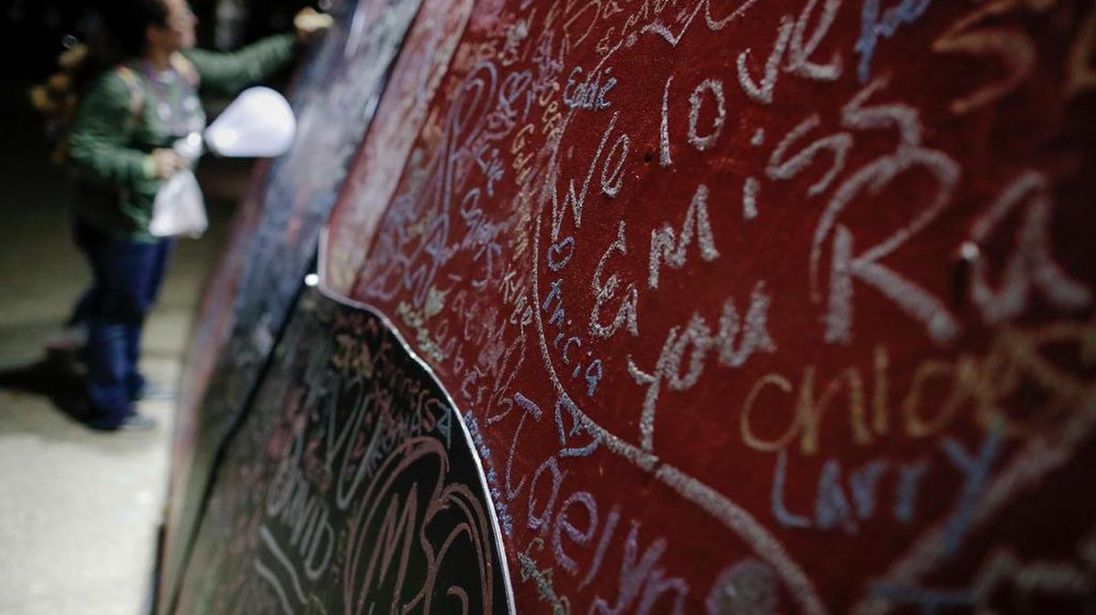 A participant writes on a message board adorned with notes for loved ones who took their own lives during an Out of the Darkness Walk event organized by the Cincinnati Chapter of the American Foundation for Suicide Prevention in Sawyer Point park, Sunday, Oct. 15, 2017, in Cincinnati. Hundreds of supporters gathered to draw attention to and raise funds for the prevention of suicide that ranks as the tenth leading cause of death in the United States overall according to the Centers for Disease Control (CDC).