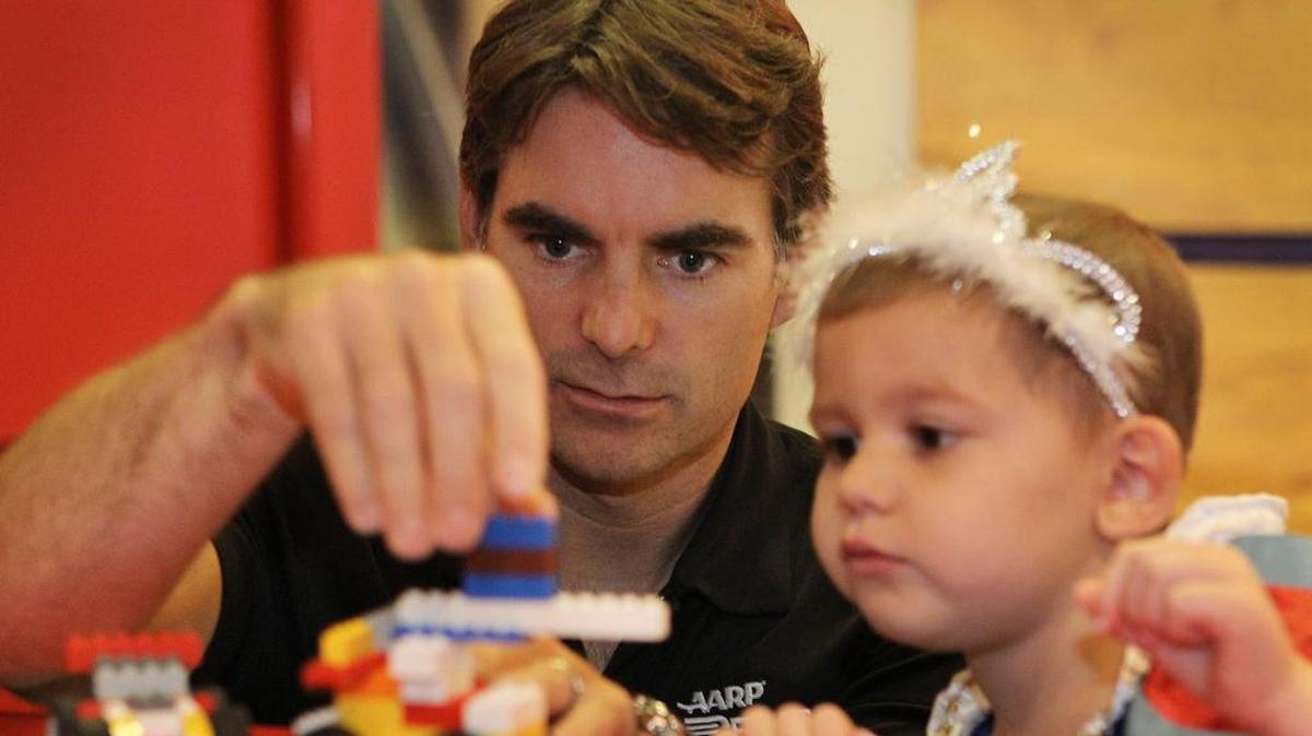 NASCAR star Jeff Gordon, an advocate for helping find a cure for pediatric cancer, helps Alaina Jones assemble a toy race car at a 2012 event assisted by Cancer Care Services.