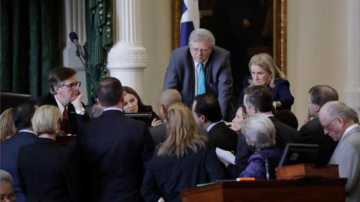 Texas senators gather around Lt. Gov. Dan Patrick, left, during a floor debate. Sen. Kirk Watson, D-Austin, has introduced bills to repair damage done to the state’s Public Information Act in recent court decisions.