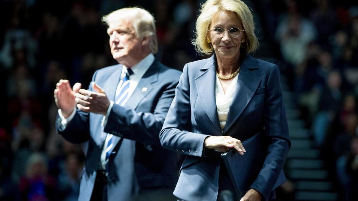 President-elect Donald Trump applauds after his pick for Education Secretary, Betsy DeVos, finishes speaking at a rally Dec. 9 in Grand Rapids, Mich.