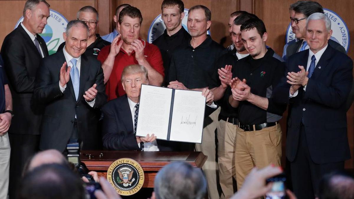 President Donald Trump holds up the signed Energy Independence Executive Order Tuesday at EPA headquarters.