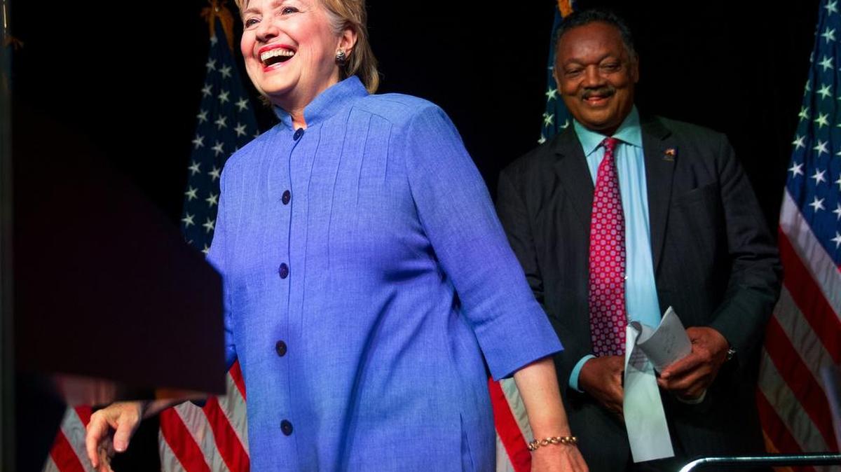 Democratic presidential candidate Hillary Clinton, followed by Rev. Jessie Jackson, arrives at June 27 event in Chicago.